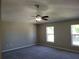 Bedroom featuring plush gray carpeting, a ceiling fan, and two bright windows at 115 Royalty Cir, Sanford, FL 32771