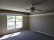 A serene bedroom features a ceiling fan and a large window at 115 Royalty Cir, Sanford, FL 32771