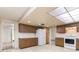 Bright kitchen featuring white appliances, skylight, and wood cabinetry at 120 Lake Dr, Oviedo, FL 32765