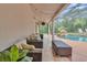 Relaxing covered patio with comfortable seating and a view of the screened-in pool and waterfall feature at 137 Tangerine Ave, Oviedo, FL 32765