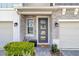 Inviting front door with stone accents, decorative wreath, and manicured green bushes at 1371 Captiva Cv, Sanford, FL 32771