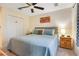 Cozy bedroom featuring queen-sized bed, ceiling fan, and wood accents at 141 Pompano Beach Dr, Kissimmee, FL 34746