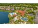 Aerial view showcasing a community pool, clubhouse, playground, and basketball court surrounded by lush landscaping and a lake at 141 Pompano Beach Dr, Kissimmee, FL 34746