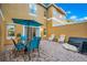 Outdoor patio area featuring a blue glass top table, blue chairs, an umbrella, and white chairs at 141 Pompano Beach Dr, Kissimmee, FL 34746