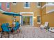 Outdoor patio area featuring a blue glass top table, umbrella, blue chairs and two white chairs at 141 Pompano Beach Dr, Kissimmee, FL 34746