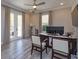 Bright home office featuring a modern desk, two chairs, and a large window overlooking the outdoor area at 1447 Lake George Dr, Lake Mary, FL 32746