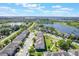 Aerial shot of a residential community featuring townhomes and scenic lakes under a partly cloudy sky at 15221 Sunrise Grove Ct, Winter Garden, FL 34787