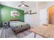 This bedroom is decorated with a green accent wall, wood furniture, and modern rug at 15221 Sunrise Grove Ct, Winter Garden, FL 34787