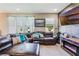 Cozy living room with a leather sofa, custom wood accent wall, and a flat screen television at 15221 Sunrise Grove Ct, Winter Garden, FL 34787