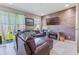 Comfortable living room with a leather sofa, custom wood accent wall, and sliding glass doors at 15221 Sunrise Grove Ct, Winter Garden, FL 34787