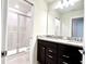 Modern bathroom with double sinks and a tiled shower with a glass door at 16248 Saint Kitts Cir, Clermont, FL 34714