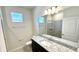 Bathroom with a granite vanity, shower, and a mirrored wall at 16248 Saint Kitts Cir, Clermont, FL 34714