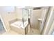 Bright bathroom featuring a tub and a glass-enclosed shower with tiled walls at 16248 Saint Kitts Cir, Clermont, FL 34714