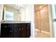 Well-lit bathroom featuring a granite countertop, dark cabinetry, and a glass-enclosed shower at 16248 Saint Kitts Cir, Clermont, FL 34714