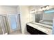 Bathroom view showcasing double sinks with granite counters, vanity and a separate shower room at 16248 Saint Kitts Cir, Clermont, FL 34714