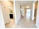 Open hallway view featuring neutral tile flooring, a staircase, and access to the living spaces at 16248 Saint Kitts Cir, Clermont, FL 34714