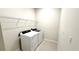 Laundry room featuring a white washer and dryer with a wire rack above at 16248 Saint Kitts Cir, Clermont, FL 34714