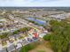 This aerial image showcases a house nestled among other houses, complete with a community lake and many trees at 16805 Sunrise Vista Dr, Clermont, FL 34714