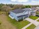 An aerial view of a two-story blue home with a manicured lawn, a backyard, and a driveway at 16805 Sunrise Vista Dr, Clermont, FL 34714