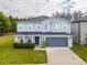 Charming two-story blue home with white shutters, a well-maintained lawn, and a two-car garage at 16805 Sunrise Vista Dr, Clermont, FL 34714