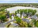 Aerial view of charming neighborhood houses in a circle on a street near a serene lake with a fountain at 217 Oak Park Pl, Casselberry, FL 32707