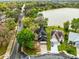 Aerial view of a home and a lake, surrounded by lush green trees and a road with passing traffic at 217 Oak Park Pl, Casselberry, FL 32707