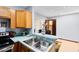 Kitchen with stainless sink, wooden cabinetry, and pass-through to another room at 217 Oak Park Pl, Casselberry, FL 32707