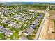 Aerial view of a neighborhood with solar panels and lush trees around the homes at 2224 Romanum Dr, Winter Garden, FL 34787