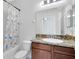 Bright bathroom featuring a granite countertop vanity, toilet, and a shower with colorful curtains at 2224 Romanum Dr, Winter Garden, FL 34787