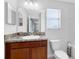 Bathroom showcasing a granite countertop vanity, sink, a toilet, and a window with natural light at 2224 Romanum Dr, Winter Garden, FL 34787