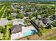 Aerial view of a community pool with lounge chairs, covered area, and a playground nestled among trees and homes at 2224 Romanum Dr, Winter Garden, FL 34787