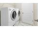 The laundry room has a side-by-side washer and dryer set with a wire shelf above at 2224 Romanum Dr, Winter Garden, FL 34787