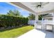 Outdoor kitchen features a built-in grill and mini-fridge overlooking the manicured lawn at 2224 Romanum Dr, Winter Garden, FL 34787