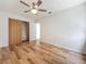 A bright bedroom features wood-look floors, fan, and closet for ample storage at 2253 Atrium Cir, Orlando, FL 32808