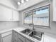 Bright kitchen sink with a large window view and neutral countertops and cabinets at 2253 Atrium Cir, Orlando, FL 32808