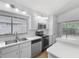 Well-lit kitchen with stainless steel appliances, white cabinets, and eat-in counter at 2253 Atrium Cir, Orlando, FL 32808