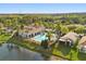 Aerial view of community clubhouse, pool, and scenic landscaping by the lake at 237 Rialto Rd, Kissimmee, FL 34759