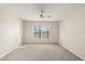 Neutral bedroom with a ceiling fan, large window, and light-colored carpet at 237 Rialto Rd, Kissimmee, FL 34759