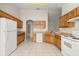 Well-lit kitchen featuring tile flooring, wooden cabinetry, and white appliances at 237 Rialto Rd, Kissimmee, FL 34759