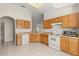 Traditional-style kitchen featuring wood cabinets, white appliances, and tile flooring at 237 Rialto Rd, Kissimmee, FL 34759