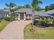 Inviting home with a brick driveway, palm trees and beautiful landscaping at 2480 Northumbria Dr, Sanford, FL 32771