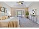 Bright main bedroom with a tray ceiling, neutral decor, and a cozy seating area by the bay window at 2480 Northumbria Dr, Sanford, FL 32771