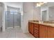 Well-lit bathroom featuring a glass shower door, granite countertops, and dual sinks at 321 Pendant Ct, Kissimmee, FL 34747