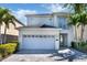 Beautiful two-story home featuring a two-car garage, well-manicured landscaping, and charming architectural details at 321 Pendant Ct, Kissimmee, FL 34747