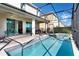 Beautiful screened in pool with a spa and a patio with chairs and an outdoor dining area at 321 Pendant Ct, Kissimmee, FL 34747