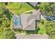 Aerial view of the rear of the home, highlighting the screened pool, brick patio, and lush landscaping at 3780 Woodhurst Ct, Oviedo, FL 32766