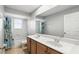 Bathroom featuring a double sink, walk in shower and window over looking the front yard at 3780 Woodhurst Ct, Oviedo, FL 32766