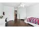 Light and airy bedroom featuring dark hardwood floors, a ceiling fan, and white furnishings at 3780 Woodhurst Ct, Oviedo, FL 32766