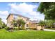 Gorgeous two-story house with a three-car garage, lush green lawn and mature palm trees at 3780 Woodhurst Ct, Oviedo, FL 32766