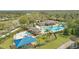 Aerial view of community pool area featuring waterslides, covered seating, splashpad, and surrounding landscape at 3780 Woodhurst Ct, Oviedo, FL 32766